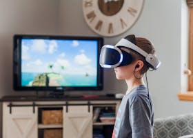 A young boy using a VR headset, fully engaged in a virtual reality experience indoors.